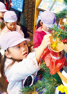 写真:クリスマスツリーを飾り付ける園児たち