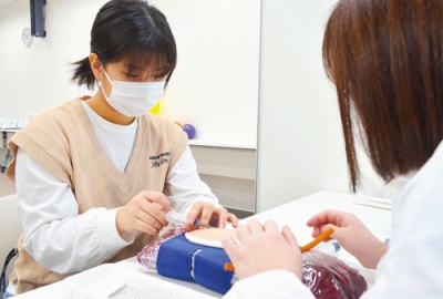 写真:体験コーナーで擬似採血に臨む来場者