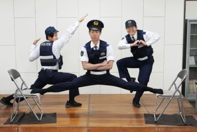 写真:格闘漫画「刃牙」シリーズの有名シーンを再現したポーズを決める長崎県警南島原署の青栁匡彦巡査部長(中央)ら=南島原署