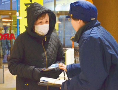 写真:来店客に啓発品を手渡し、交通安全を呼びかける室蘭署員