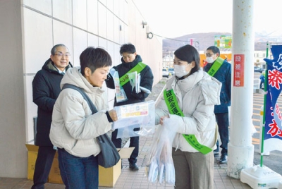 写真:来店者にチラシを配布して特殊詐欺に注意を呼びかける啓発参加者ら