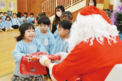 写真:サンタからクリスマスプレゼントをもらう園児たち