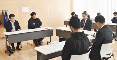 写真:給食費値上げに関する審議内容を把握する委員たち