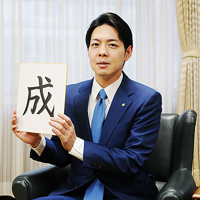 写真:「成」の字が書かれた色紙を手にする鈴木知事