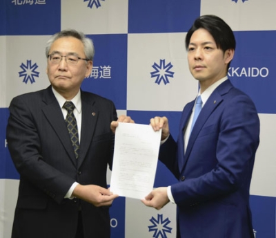 写真:北海道電力の斎藤晋社長(左)に要請文を手渡す鈴木直道知事=24日午後、札幌市