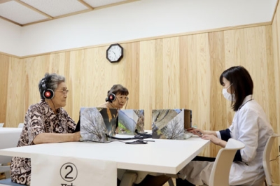 写真:秋田県能代市で行われた検査会で、聴力検査をする参加者=8月
