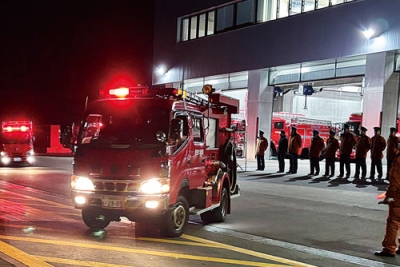 写真:消防庁舎を出発する消防団車両