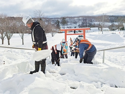 写真:神社の参道を除雪する高橋建設社員ら(提供写真)