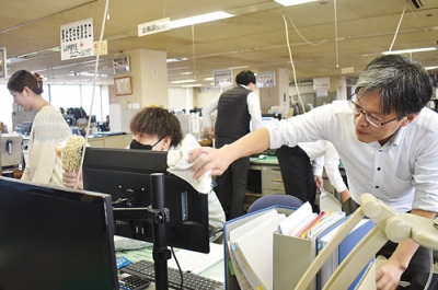写真:仕事納めでデスク回りを丁寧に清掃する職員=30日、伊達市役所