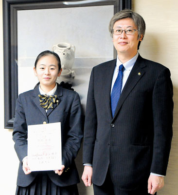 写真:ピアノコンクールの表彰状を手に笑顔を見せる岡村さん