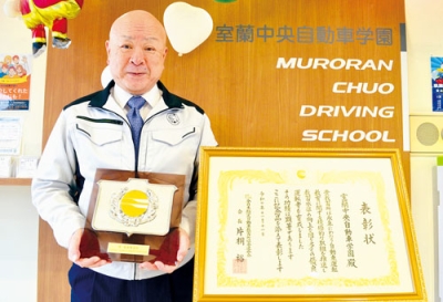写真:「優良教習所」に選ばれ、表彰楯を手に持つ室蘭中央自動車学園の武田校長