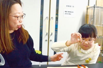 写真:ボトルキャップを材料にキーホルダーを作る親子