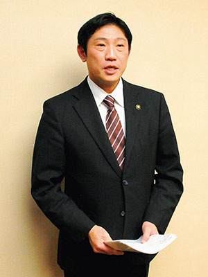 写真:協議会終了後に報道陣に取材対応する青山市長