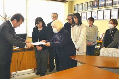 写真:千田議長(左)に公開質問状を手渡す有志の会のメンバー