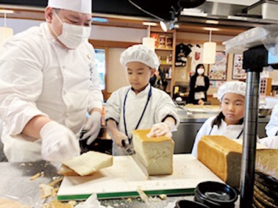 写真:パンの耳をカットする子ども(提供写真)