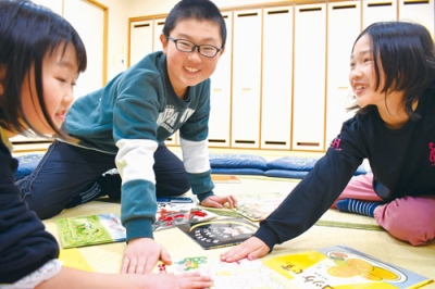 写真:目当ての絵札に元気いっぱい手を伸ばす子どもたち