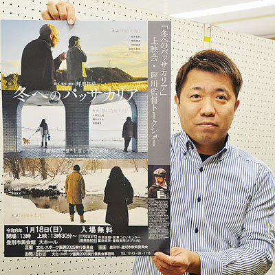 写真:「冬へのパッサカリア」のポスターを手に上映会をPRする関係者