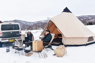 写真:雪上にテントをたて、くつろぐキャンパー