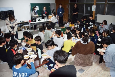 写真:一緒に作った夕食を味わう子どもたち