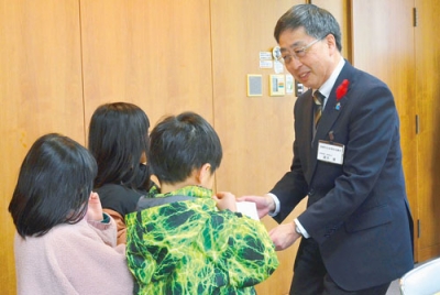 写真:室蘭市共同募金委員会へ善意を手渡す子どもたち