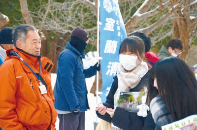 写真:試験会場へ向かう途中、高校の教師(左)からエールを送られる受験生=17日午前、室蘭工業大学