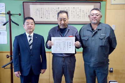 写真:山田校長(左)から感謝状を受け取った緑豊建設の工事担当者