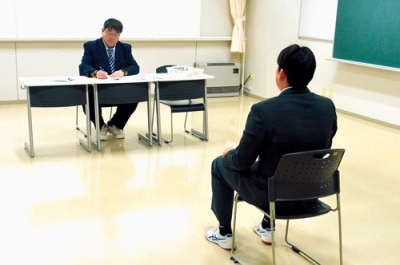 写真:面接官の質問に答える受験生(右)