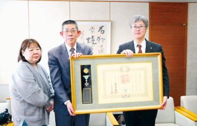 写真:市役所に受章報告をした塩谷さん(中央)