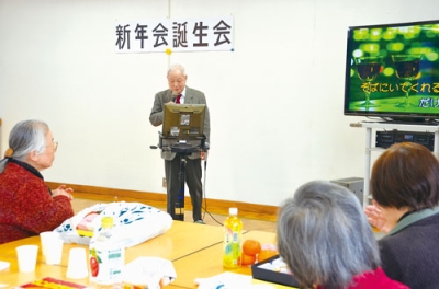 写真:余興でカラオケを披露する会員