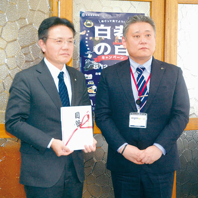 写真:目録を手渡した石見課長(右)と大塩町長