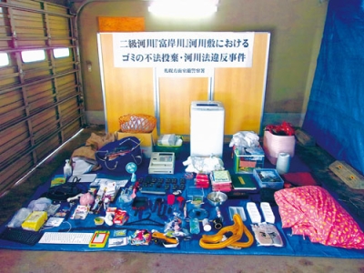 写真:登別市富岸町の河川敷に不法投棄された廃棄物(室蘭署提供)