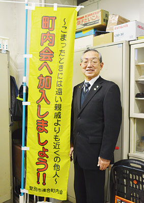 写真:町内会加入を呼びかける啓発のぼりを持つ工藤会長