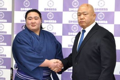 写真:新十両昇進が決まり、師匠の藤島親方(右)と握手する福崎改め藤天晴=1月、両国国技館