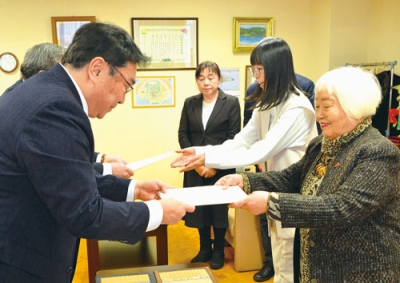 写真:小笠原市長から回答書を受け取る合田さんら有志の会