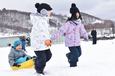写真:仲間をそりに乗せて深い雪を進む児童たち