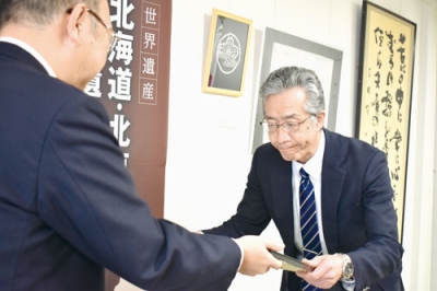 写真:教育向上への功績が認められ、表彰状を受け取る阿部校長(右)