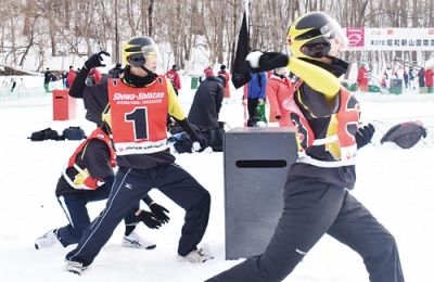 写真:スタートの合図とともに雪球を投げる選手たち