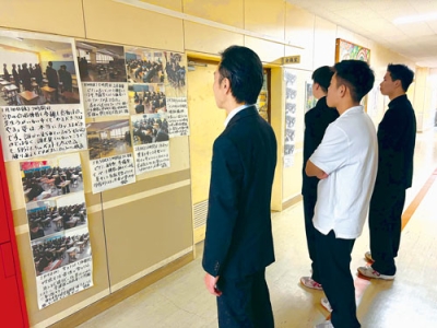 写真:足を止め各クラスの活動に目を通す生徒たち