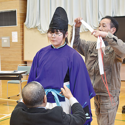 写真:伊達市仙台神楽保存会メンバーのサポートで、伝統衣装を試着する関内小児童