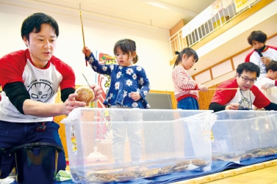 写真:特産品のホタテを釣り上げる園児