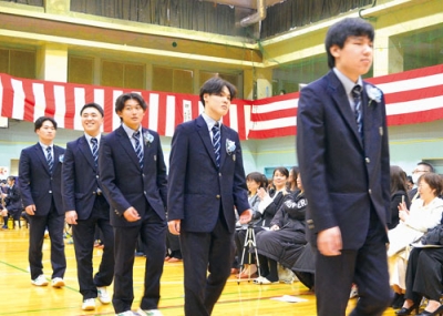 写真:保護者や後輩たちの前を笑顔で後にする卒業生