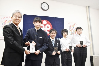 写真:影山会長(左)に善意を手渡す生徒