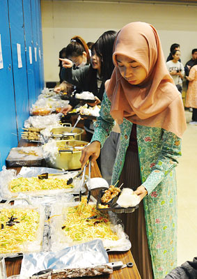 写真:各国の料理を盛り付ける参加者たち