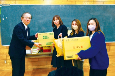 写真:平石校長(左)に雑巾を渡す郡司会長(左から2人目)