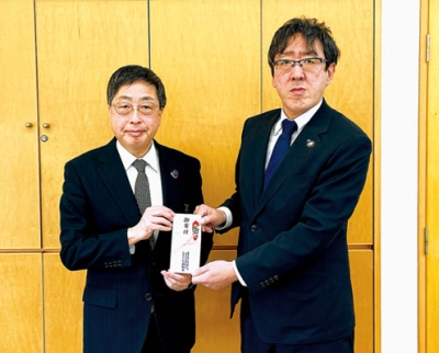 写真:髙木事務局長(左)に寄付金を手渡す山田営業局長