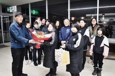 写真:閉店後の店舗で竹橋店長(左)に感謝の花束を届ける地域住民ら
