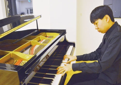 写真:サックスの経験を生かしたピアノを演奏する小野さん