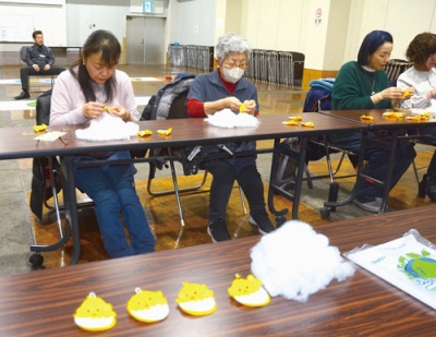 写真:手縫いでマスコットを作る女性部員