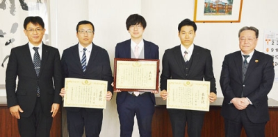 写真:表彰された安宅教諭(中央)、宇南山教諭(同右)、尾野教諭(同左)。左端は髙橋宏明胆振教育局長、右端は安宅錦也教育長