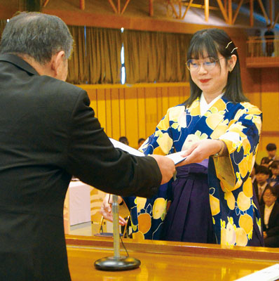 写真:総代として卒業証書を受け取るコウさん